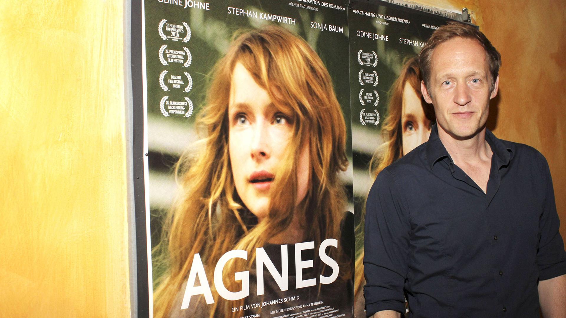 Der Schauspieler Stephan Kampwirth steht vor dem Filmplakat bei der Premiere des Kinofilms "Agnes" im Abaton Kino in Hamburg.