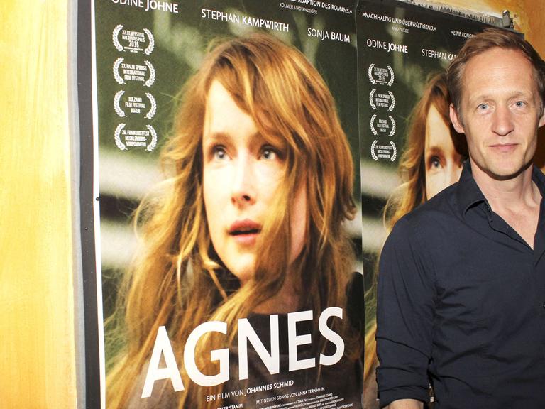 Der Schauspieler Stephan Kampwirth steht vor dem Filmplakat bei der Premiere des Kinofilms "Agnes" im Abaton Kino in Hamburg.