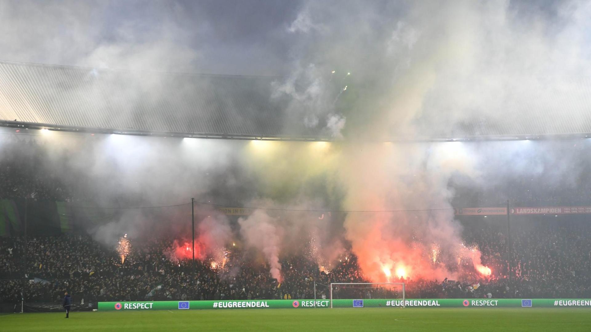 Rotterdam: Fans von Feyenoord Rotterdam zünden auf der Tribüne bengalische Feuer.