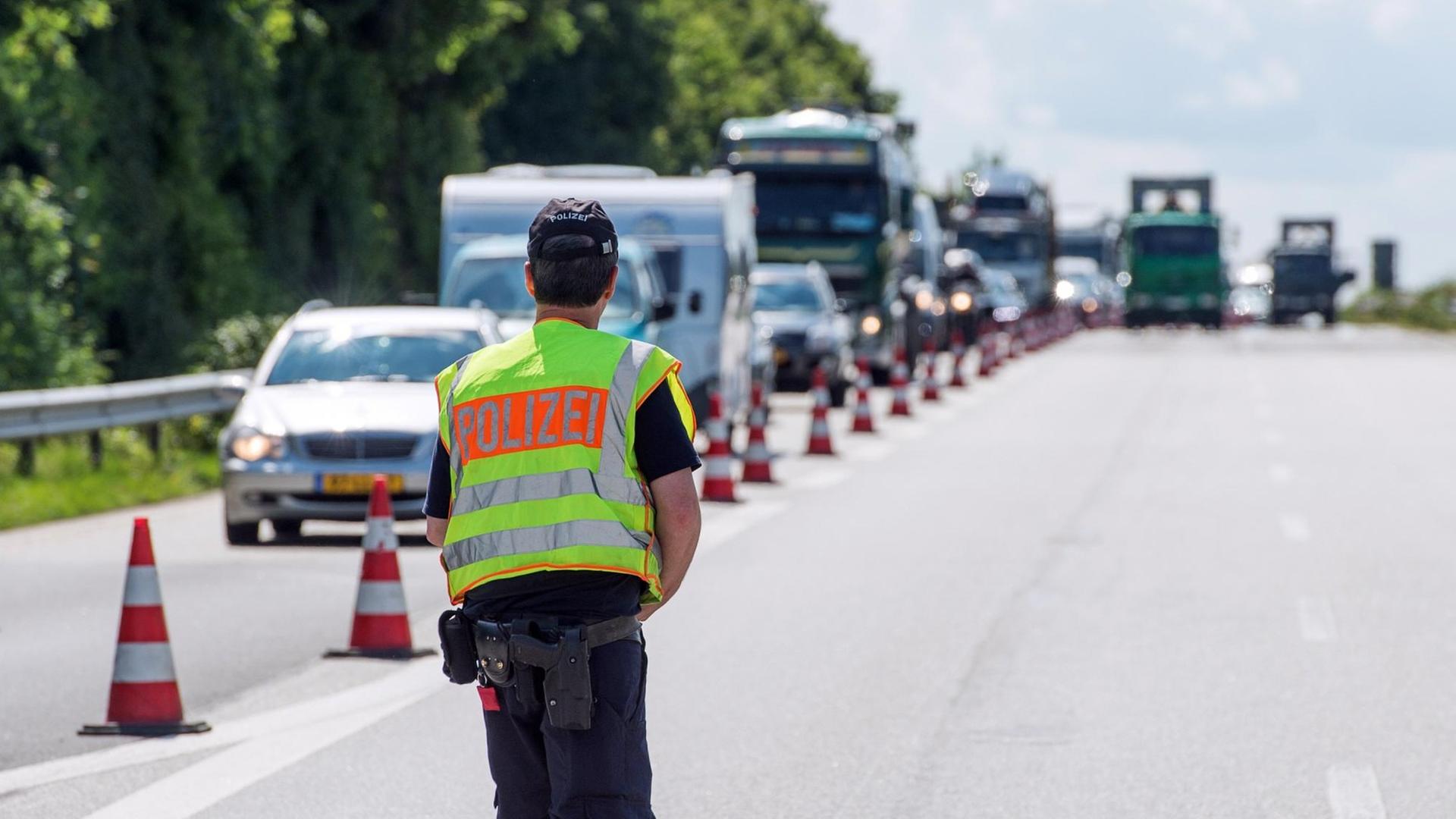 Ein Polizist kontrolliert auf der Autobahn 7 kurz vor Dänemark bei Flensburg den Verkehr.