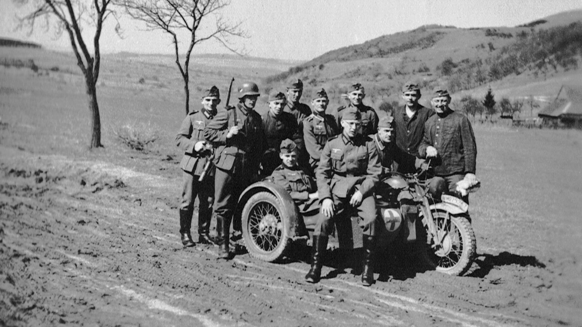 Kradfahrer und Soldaten haben sich zu einem Gruppenfoto in Frankreich aufgestellt - Herbst 1940.
