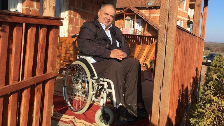 Fetah Rudi im Rollstuhl vor seinem Wohnhaus