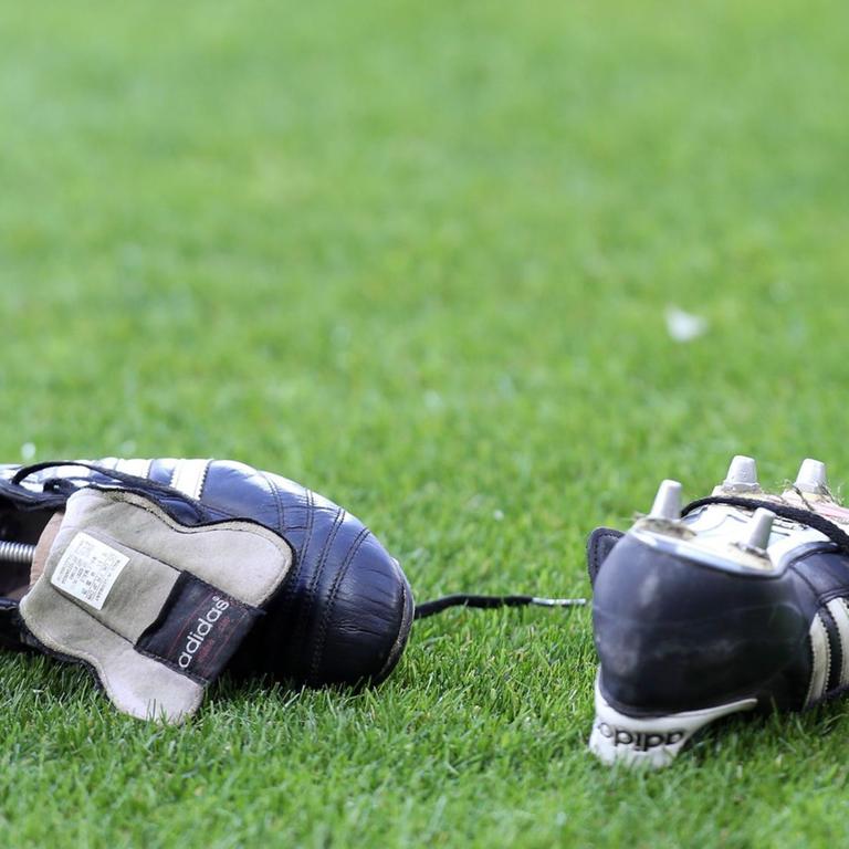 Fußballschuhe liegen auf dem Rasen.