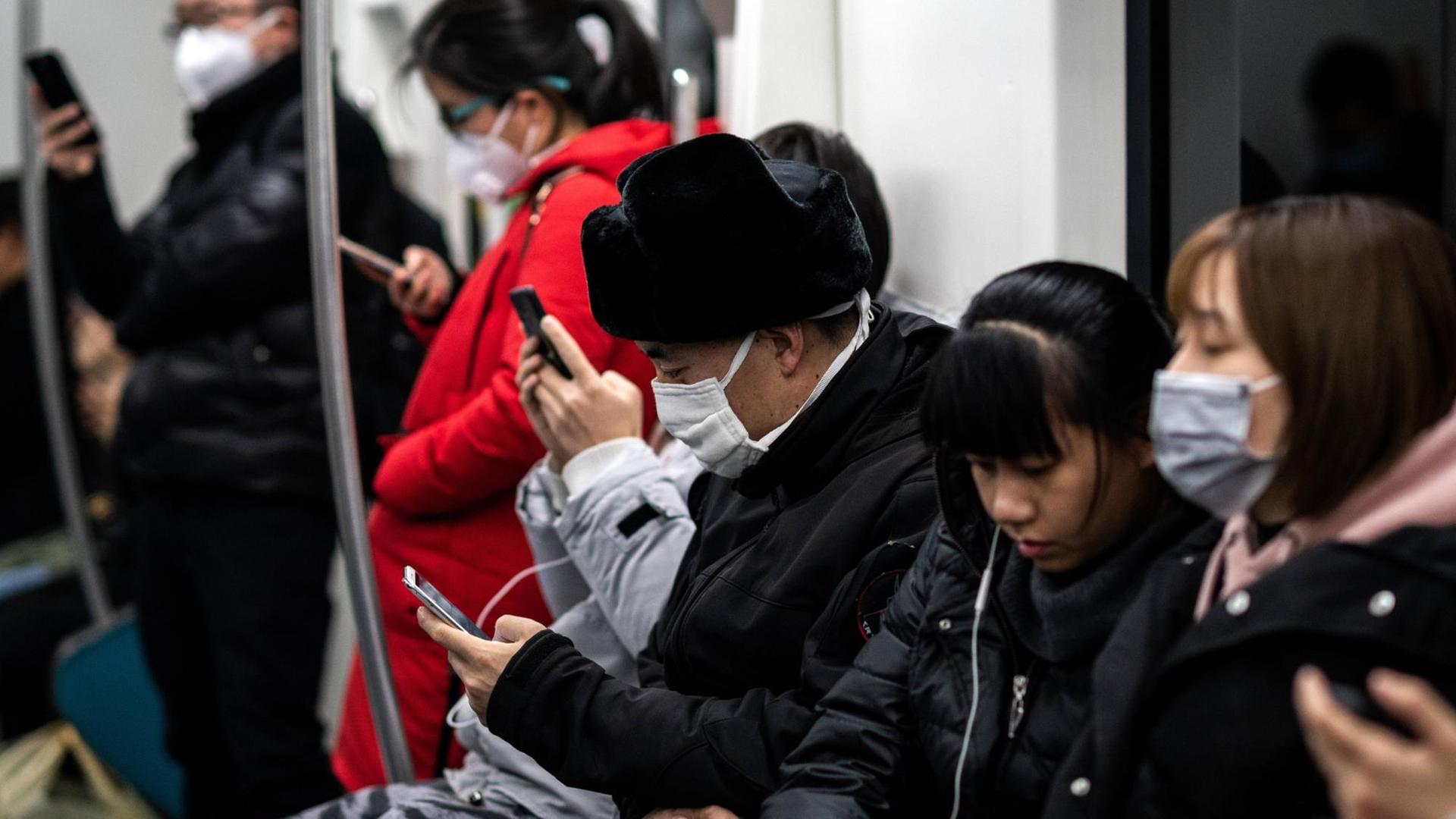 Fahrgäste mit Schutzmasken in Peking