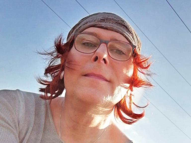 Elna hat ein Selfie von sich von unten gegen den strahlend blauen Himmel aufgenommen.
