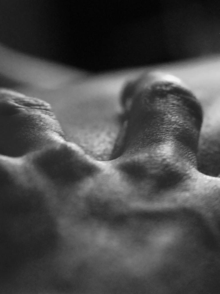 Eine Hand greift in die Haut eines anderen Menschen.