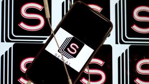 Ein Smartphone mit dem Icon der Podcast-App «Serial» liegt auf einem Bildschirm, auf dem weitere Serial-Icons zu sehen sind.
