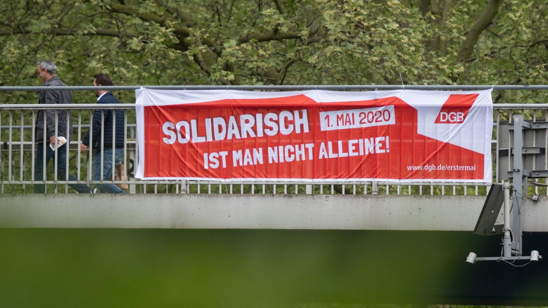 28.04.2020, Nordrhein-Westfalen, Dortmund: Ein Transparent des Deutschen Gewerkschaftsbundes (DGB) hängt an einer Brücke über der B 1. Das Mai-Motto 2020 lautet: «Solidarisch ist man nicht alleine.» Auf Grund der Corona-Epedemie findet dieses Jahr der erste ?rein digitale 1. Mai? statt. Foto: Bernd Thissen/dpa | Verwendung weltweit
