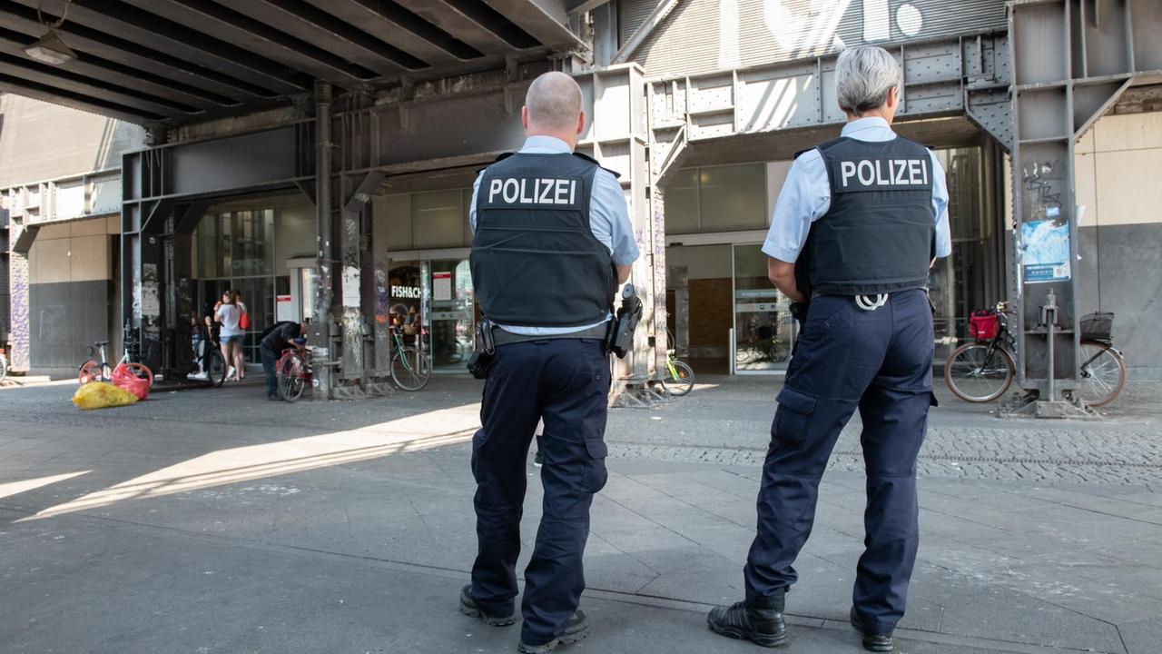 Zwei Polizeibeamte stehen in der Unterführung am Alexanderplatz in Berlin