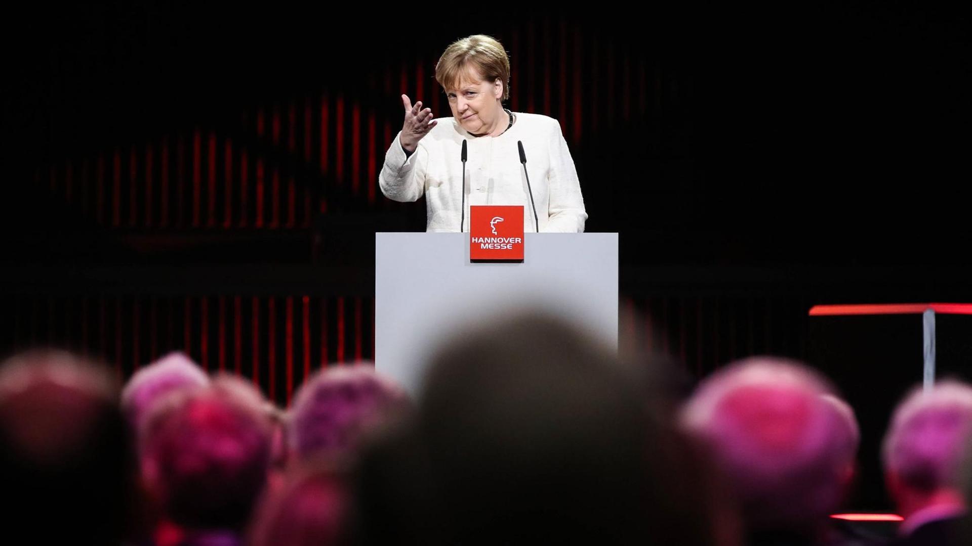 Bundeskanzlerin Angela Merkel auf der Industriemesse in Hannover im März 2019. Angela Merkel steht an einem Podium und hält eine Rede.