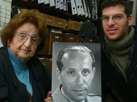 Die Witwe Miriam Weissenstein und ihr Enkelsohn Ben mit dem Foto Rudi Weissensteins im Fotolade.