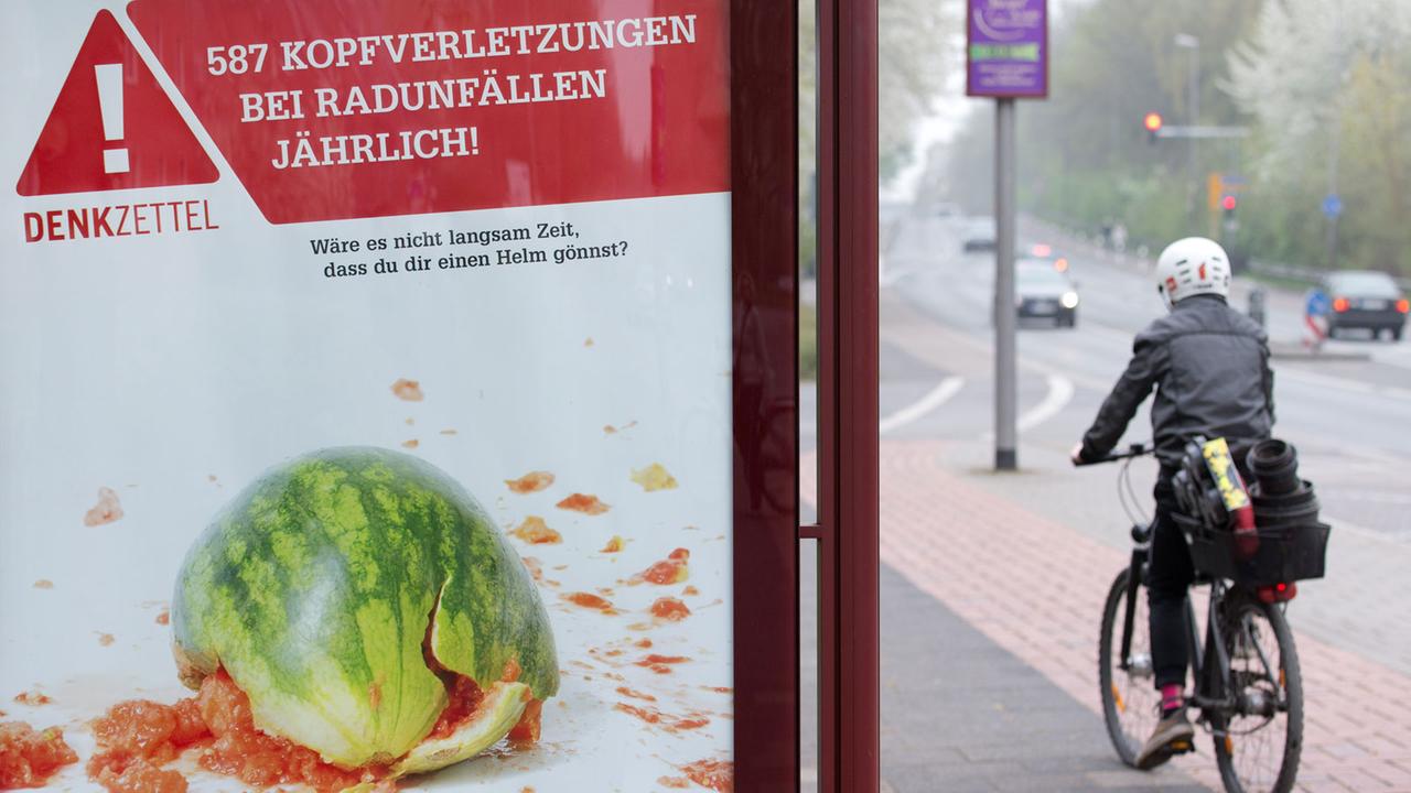 Ein Plakat informiert in Münster über Kopfverletzungen bei Radunfällen.