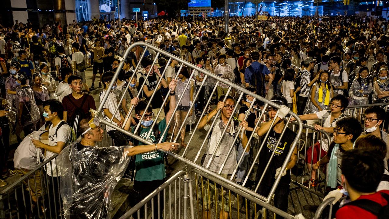 Demonstranten in Hongkong bauen Barrikaden aus Absperrzäunen.