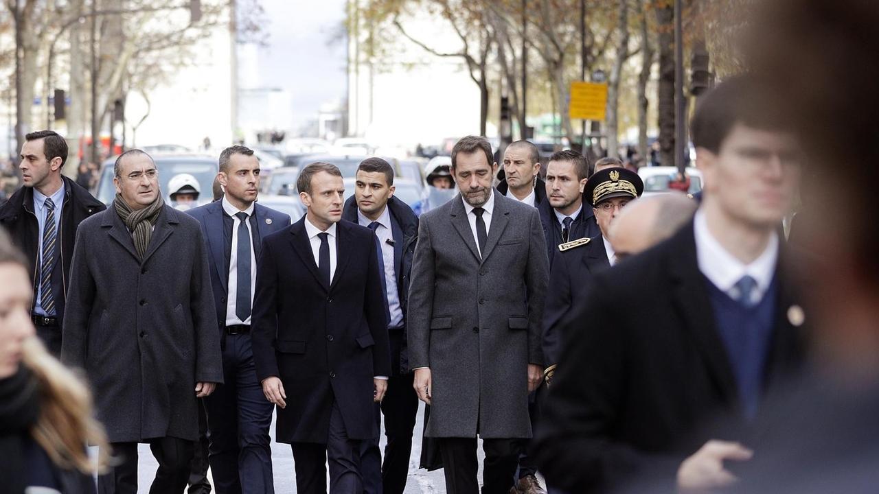 Emmanuel Macron (Mitte) und Innenminister Christophe Castaner (rechts) besichtigen am 2.12.18 den Triumphbogen in Paris nach den Krawallen vom Vortag.