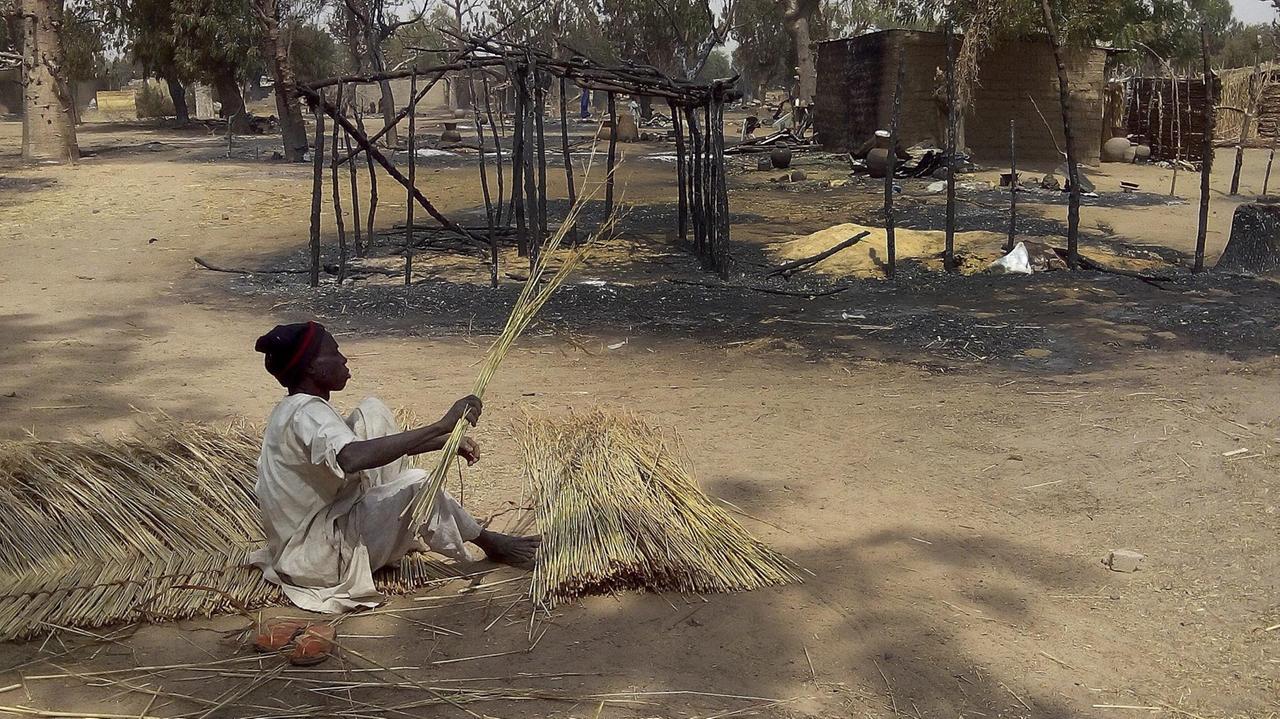 Nigeria: Ein Opfer eines Boko-Haram-Überfalls im Bundesstaat Borno in Nigeria, baut einen neuen Zaun um sein abgebranntes Haus herum. 