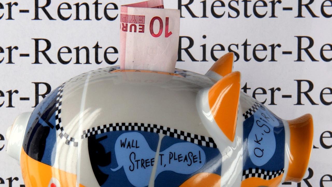 Ein Sparschwein steht vor einem Schild mit der Aufschrift Riester-Rente.
