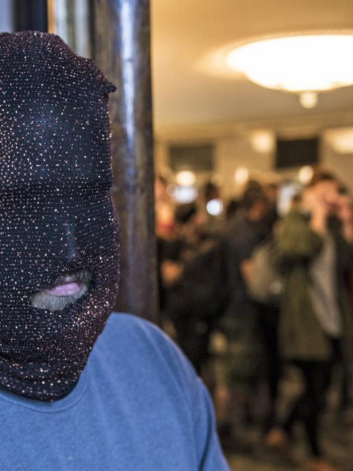 Ein Aktivist mit Maske steht in Berlin im Foyer der Volksbühne. Aktivisten haben das Gebäude besetzt.