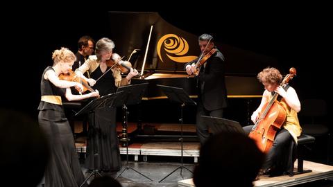 Mitglieder eines Klavierquintett mit ihren Instrumenten auf der Bühne