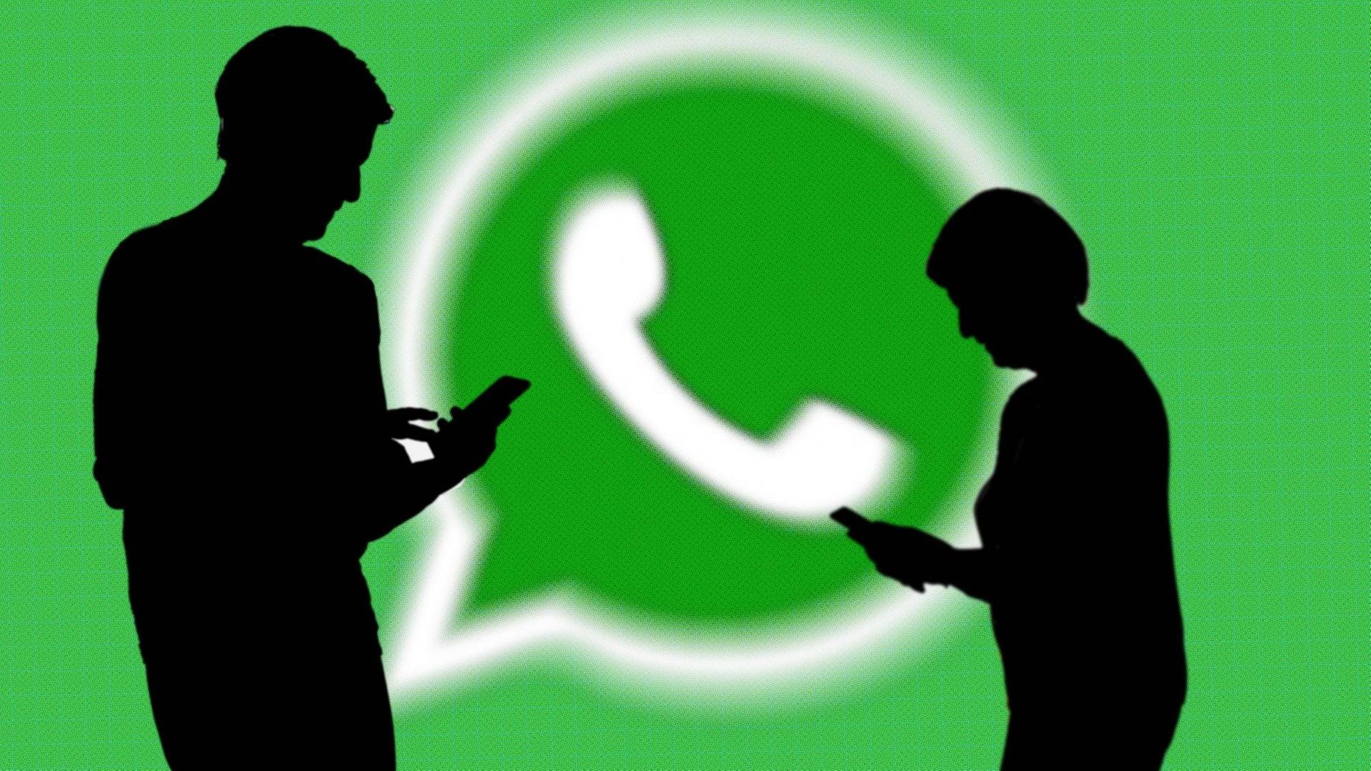 Das Logo von WhatsApp, vor dem die Silhouetten von zwei Personen zu sehen sind.