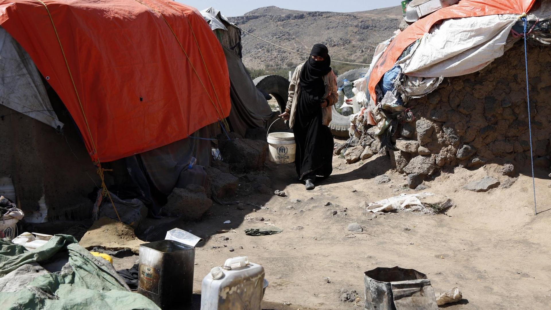 Eine Frau zwischen improvisierten Zelten in einem Flüchtlingscamp im Jemen