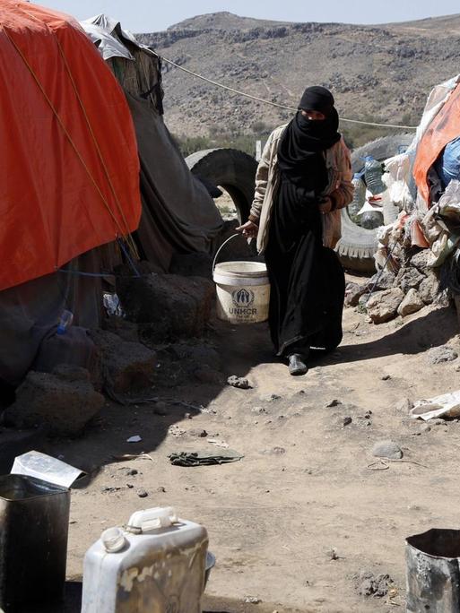 Eine Frau zwischen improvisierten Zelten in einem Flüchtlingscamp im Jemen