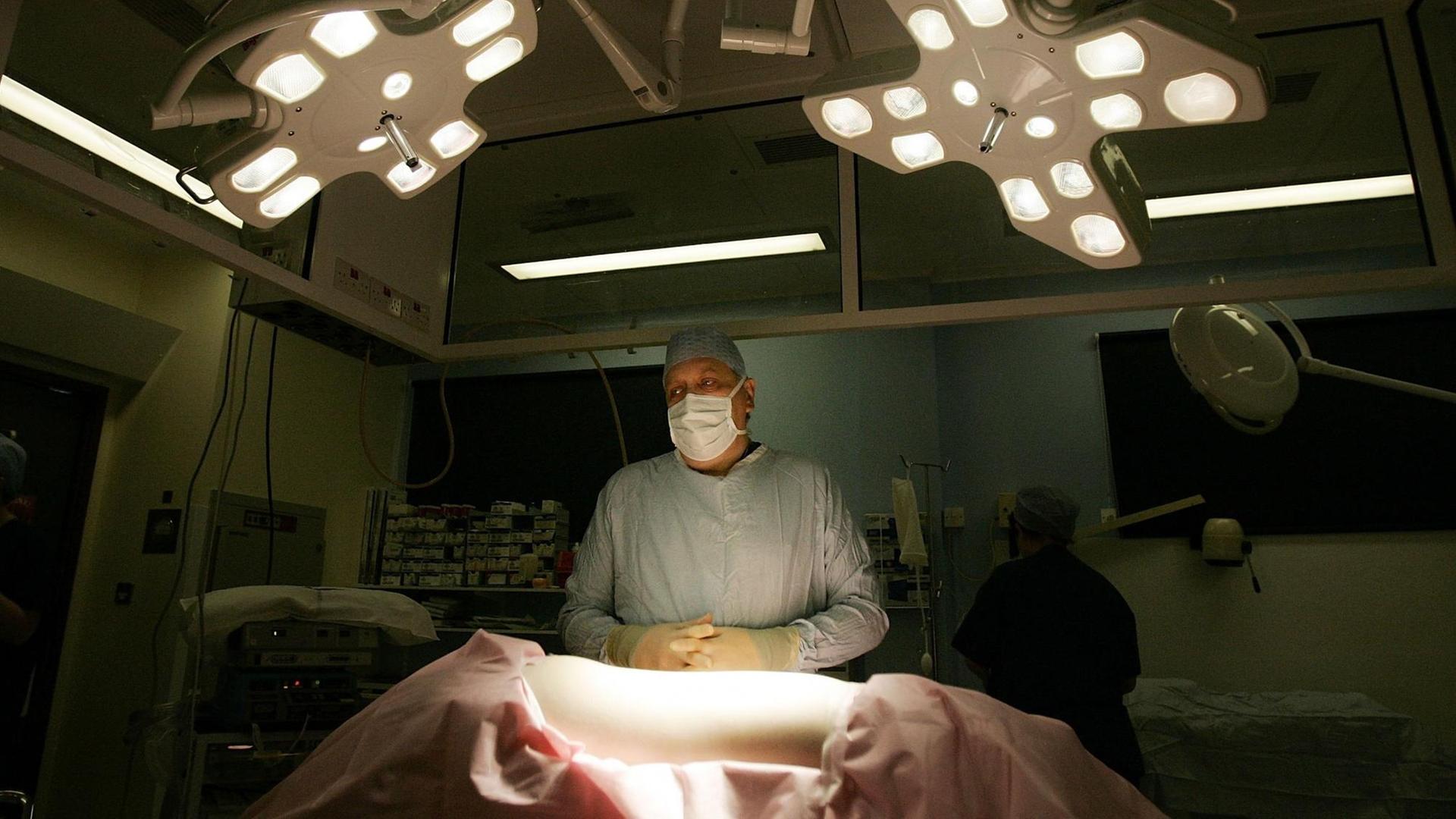 Ein Chirurg steht vor einem Patienten.