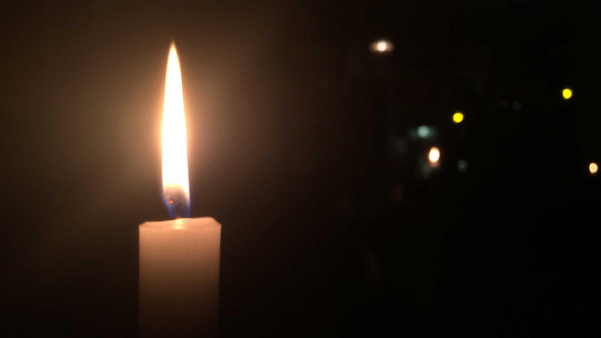 Eine Kerze brennt in der Dunkelheit.