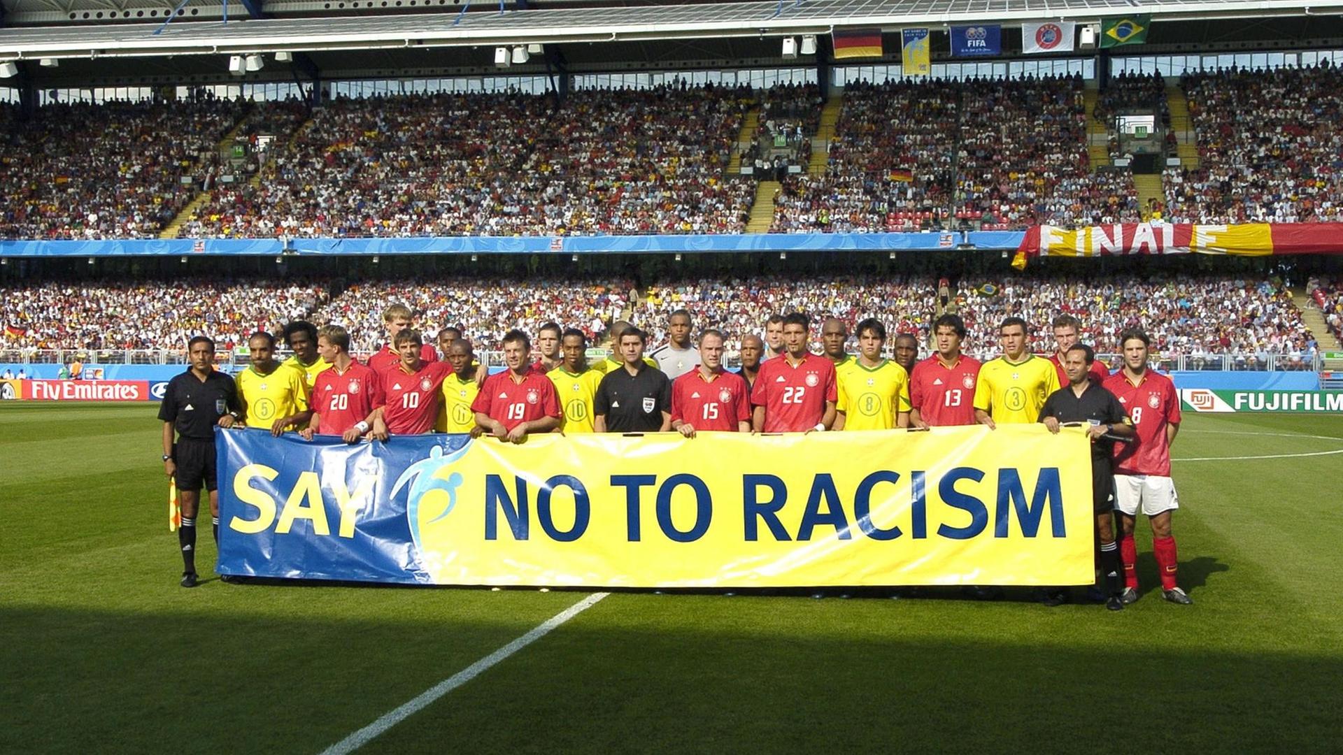 Brasilianische und deutsche Fußballer mit FIFA-Anti-Rassismus-Plakat 2006