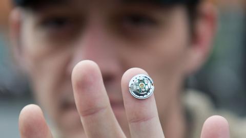 Der US-Amerikaner Tim Cannon hält durch ein Magnet-Transplantat einen Kopfhörermagneten an seinem Finger. 