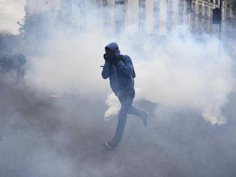 Ein Demonstrant rennt durch eine Wolke von Tränengas.