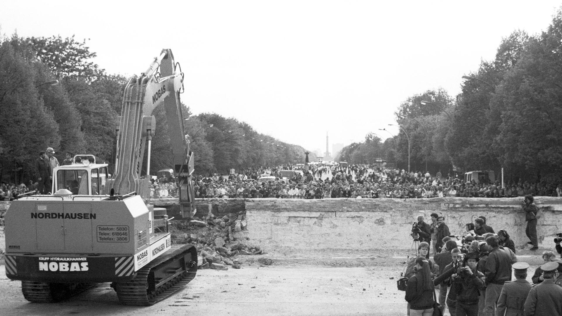 Beginn des Abrisses der Berliner Mauer am Brandenburger Tor, im Hintergrund die Siegessäule