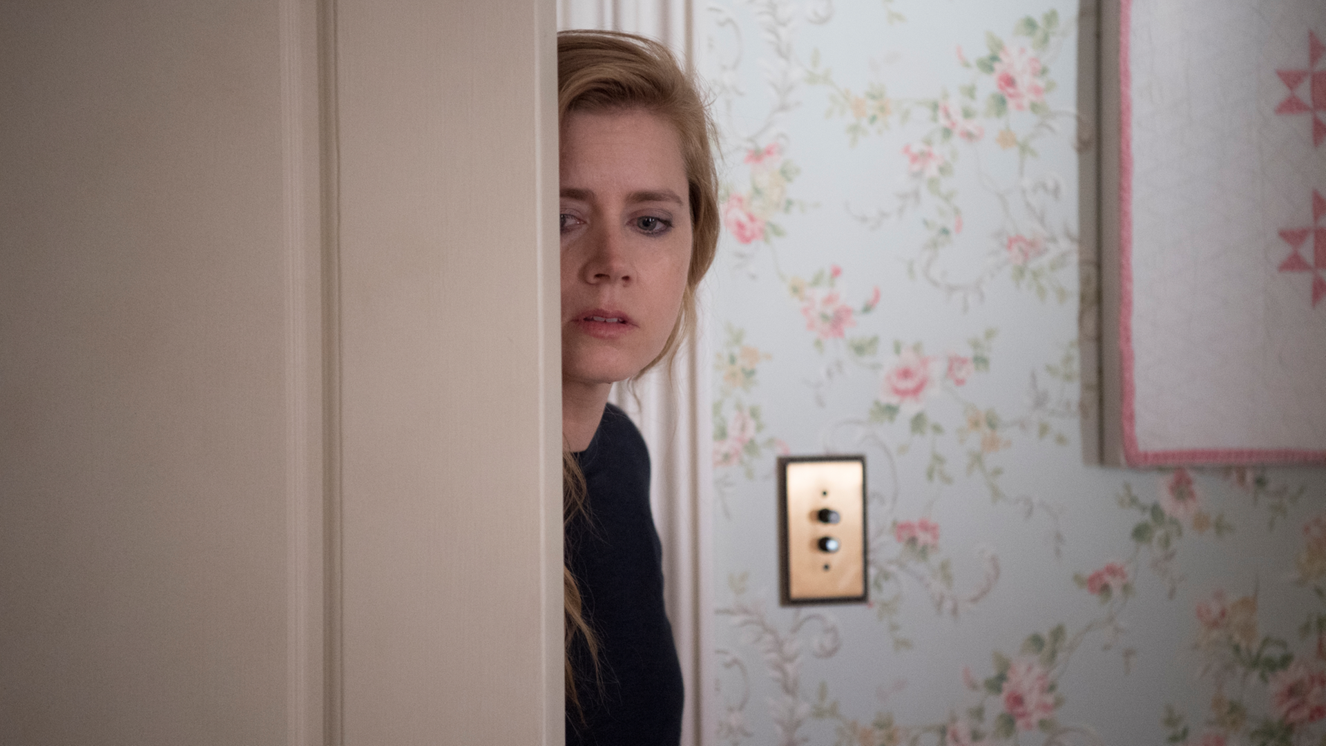 Amy Adams steht in der Serie "Sharp Objects" halb bedeckt hinter einer Zimmertür