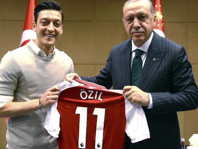 Özil und Erdogan halten ein Trikot des Fußballspielers in den Händen.