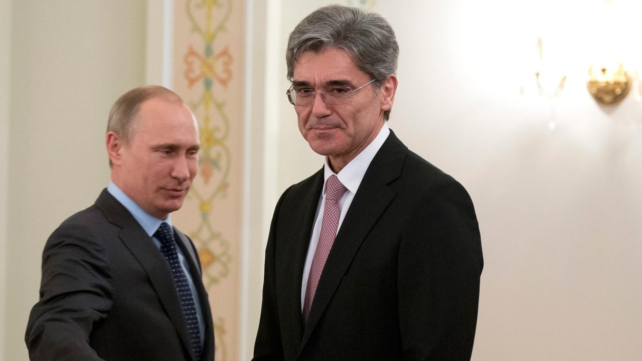 Joe Kaeser und Wladimir Putin, beide im Anzug, stehend, Putin macht eine einladende Armbewegung.