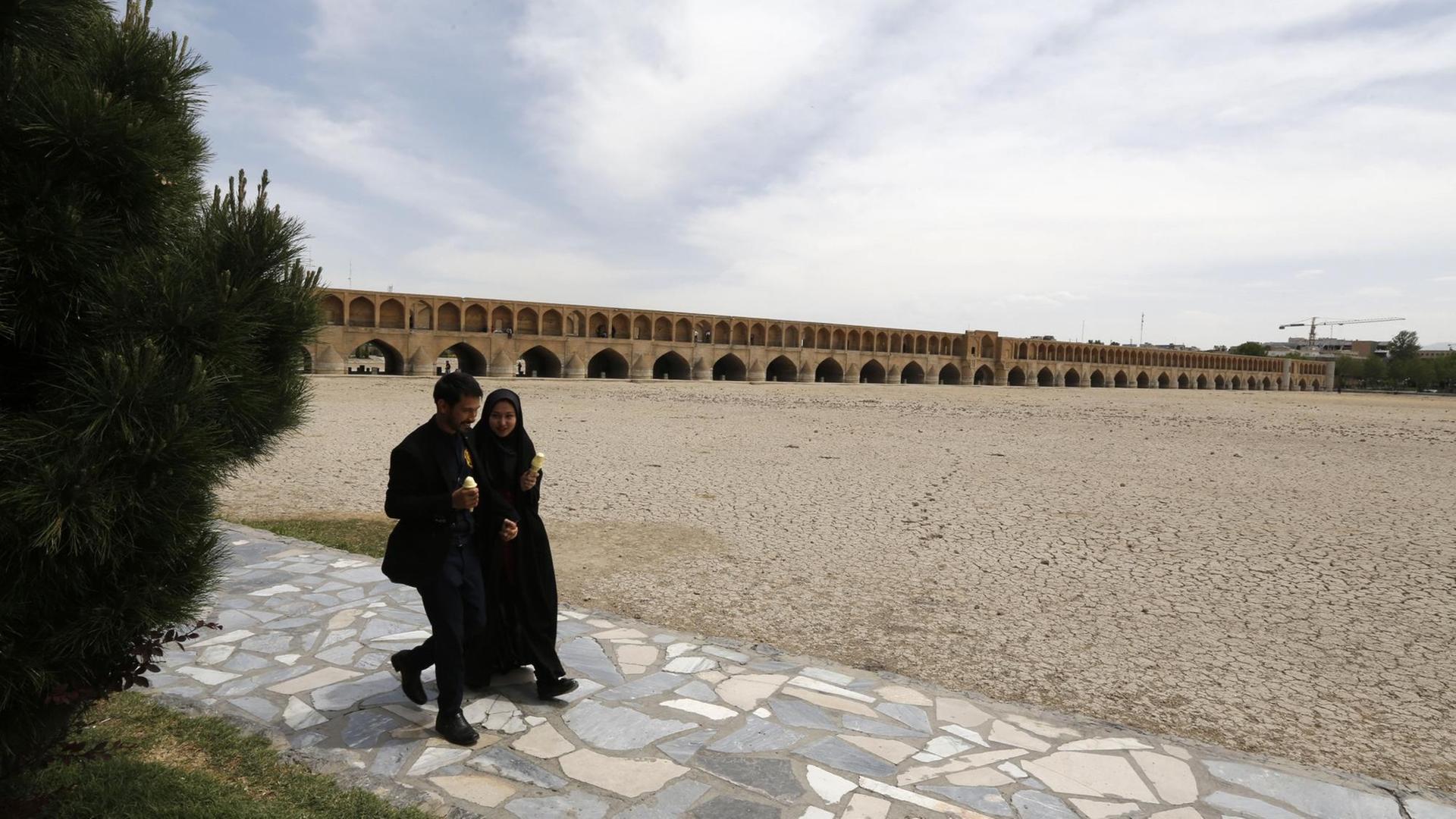 Zwei Iraner spazieren im April 2018 am Ausgetrockneten Flussbett des Zayandeh Rud an der "Si-o-Se Pol-Brücke entlang