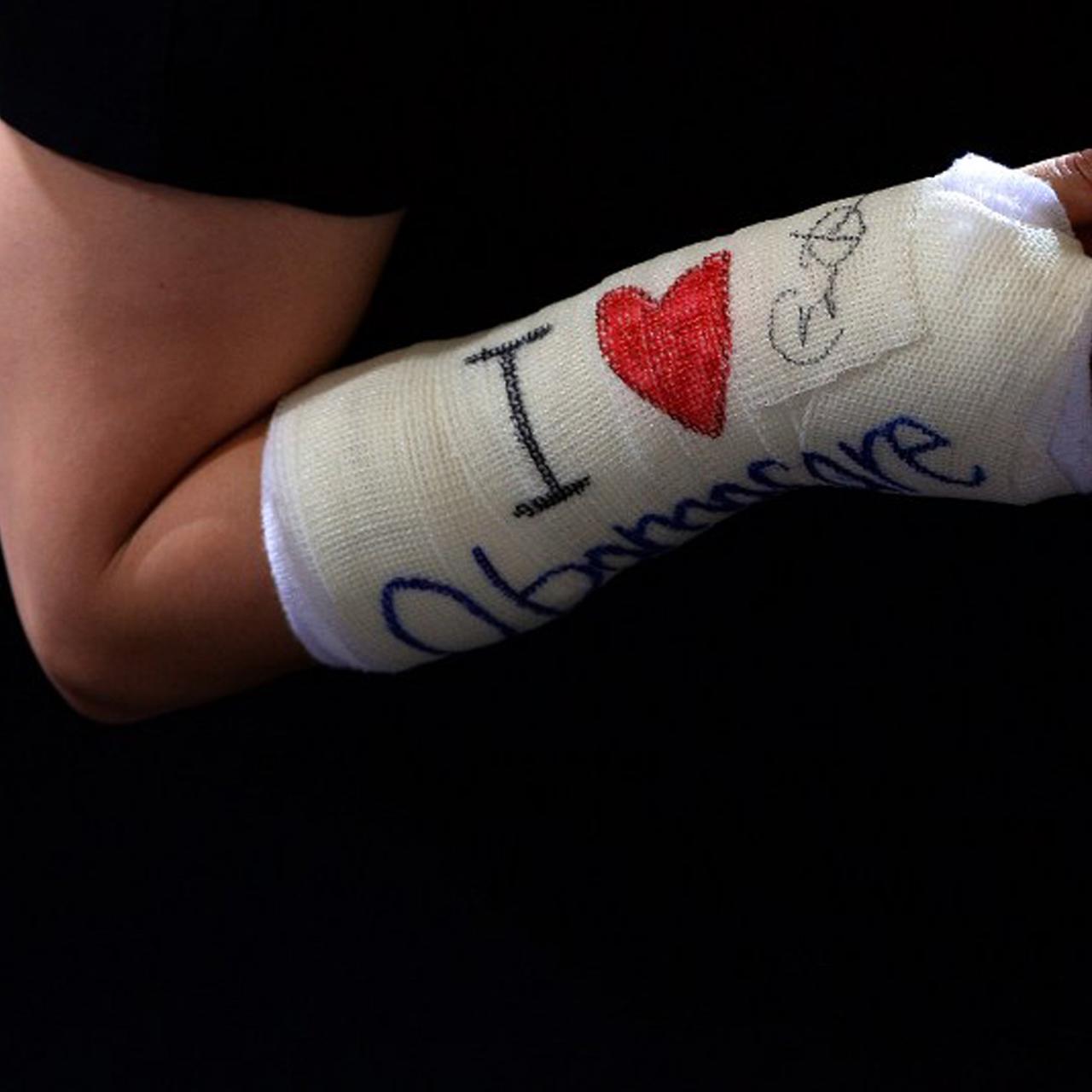 Gips am Arm mit der Aufschrift: "I love Obamacare"