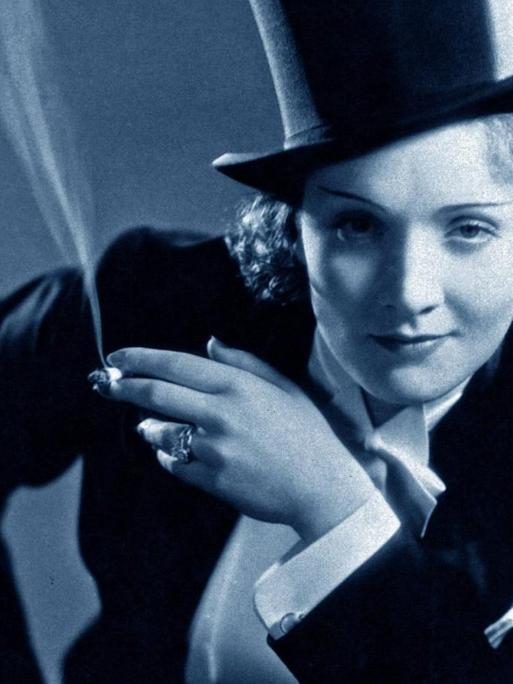 Schauspielerin Marlene Dietrich. Gekleidet in einem Frack und mit Zylinder auf dem Kopf.