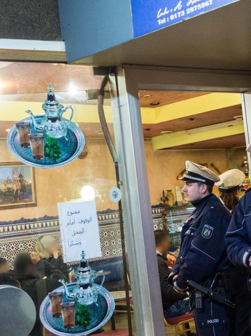 Polizei steht vor einem Cafe am 16.01.2016 im Nordafrikaner-Viertel von Düsseldorf (Nordrhein-Westfalen) während eine Razzia. Mit mehreren Hundert Beamten ist die Polizei zu einer Razzia in das sogenannte Maghreb-Viertel eingerückt.
