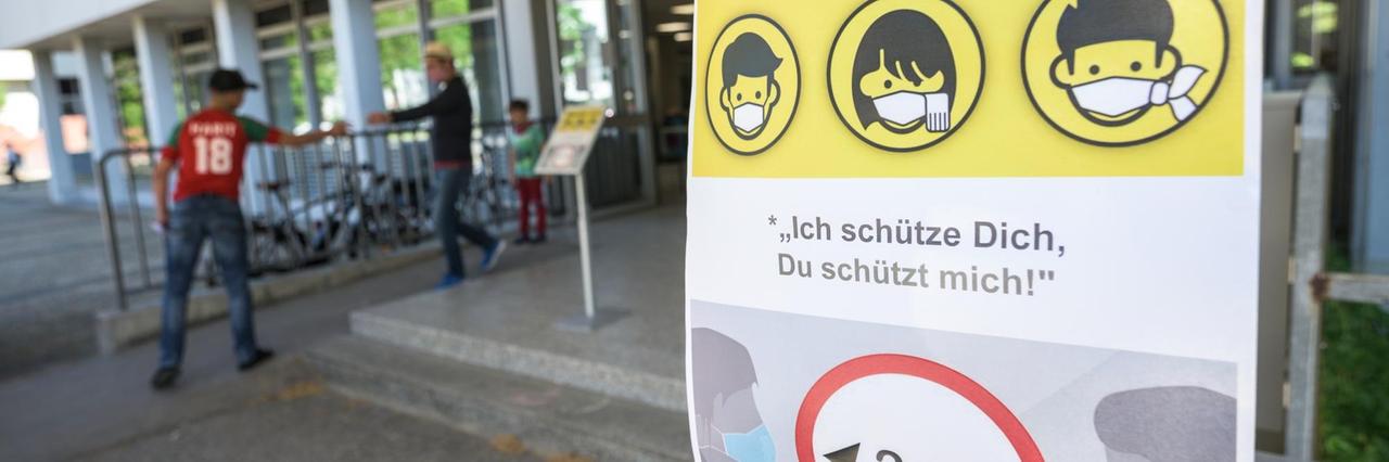Ein Plakat in Mainz weist auf die Maskenpflicht in der Berufsbildenden Schule 1 Gewerbe und Technik (BBS1) hin.