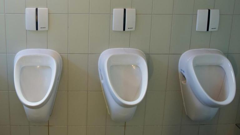 Blick in eine Herren-Toilette mit Urinalen.