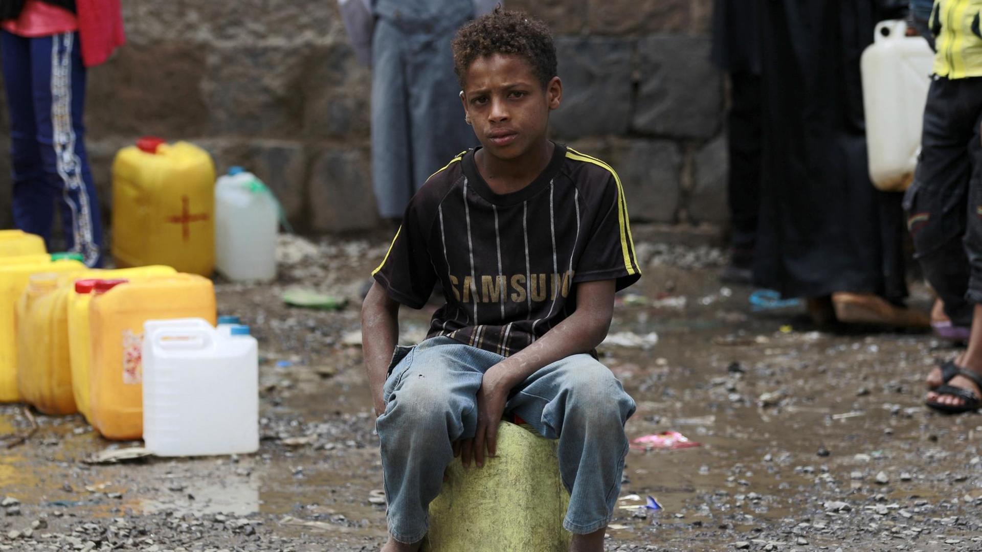 Eine Junge sitzt in der jemenitischen Hauptstadt Sanaa auf einem Wasserkanister.