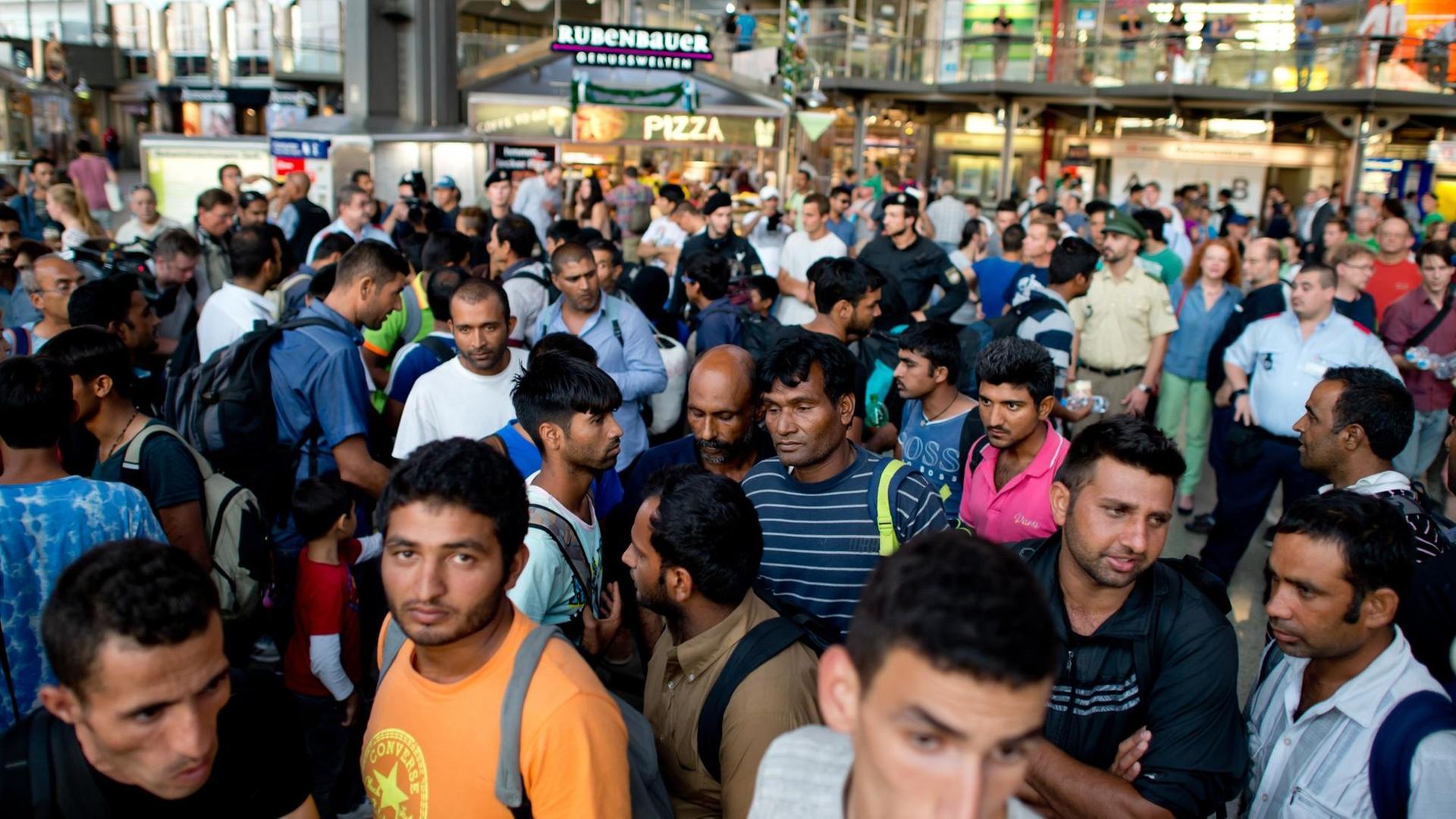 Zahlreiche Flüchtlinge aus Afghanistan, Syrien und Pakistan kommen in München mit einem Zug aus der ungarischen Hauptstadt an. Die Polizei nahm die Menschen in Empfang und führte sie zur Registrierung in eine Nebenhalle.