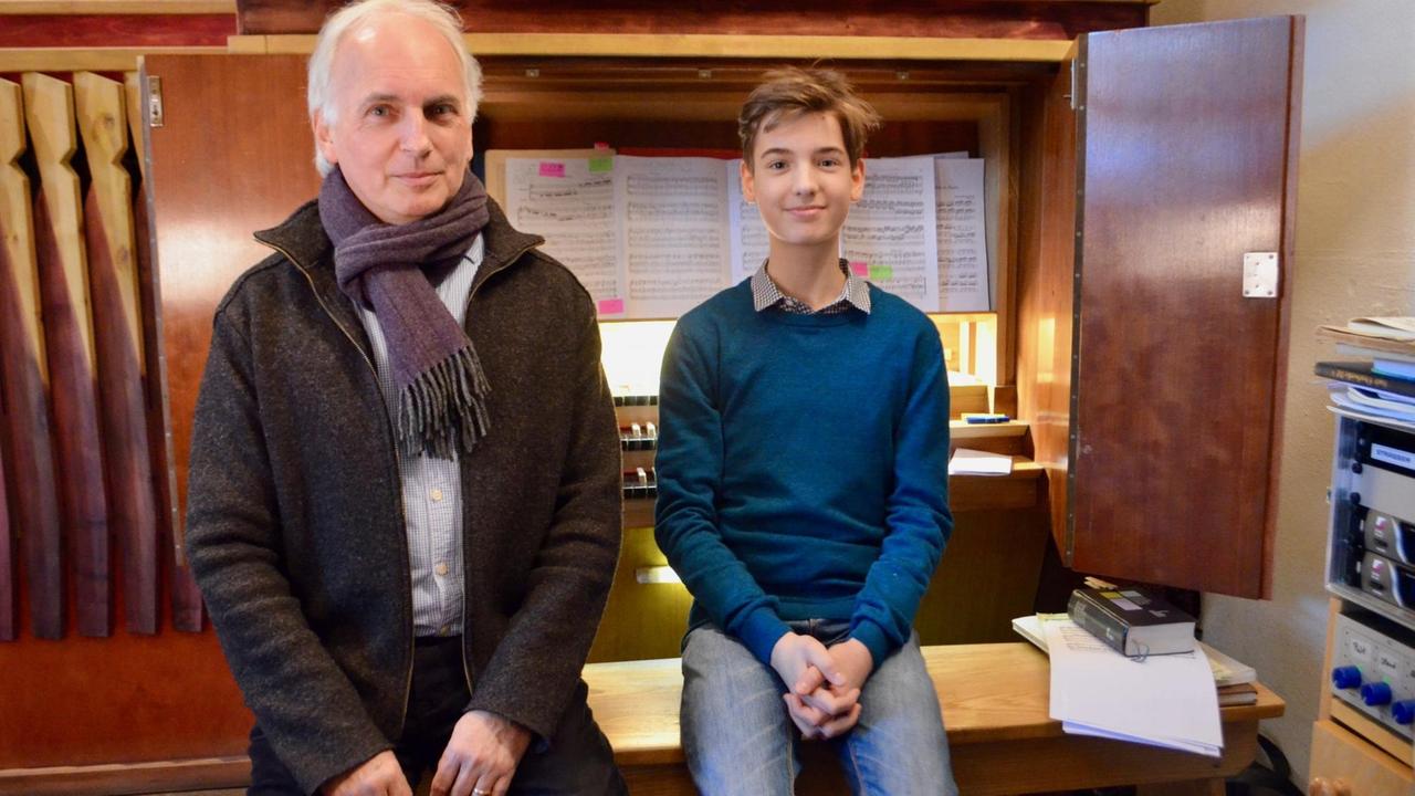 Der 13-jährige Carl Rinke und sein Orgellehrer, Domkantor Jan Ernst sitzen vor dem Spieltisch der Orgel im Schweriner Dom.