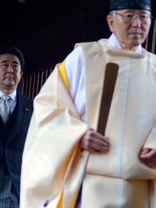 Der japanische Minsterpräsident Shinzo Abe (l.) folgt einem Priester bei seinem Besuch des Yasukuni-Schreins in Tokio am 26. Dezember 2013