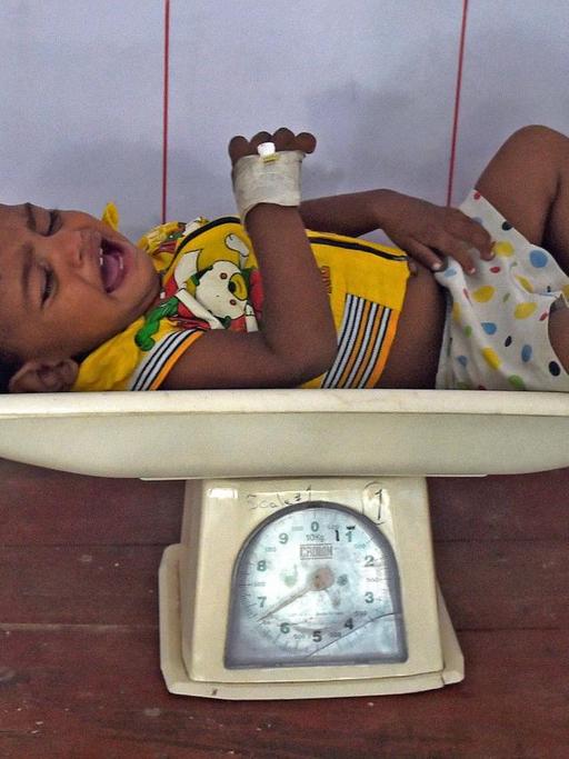 Ein Baby wird in Indien gewogen, um zu prüfen, ob es unterernährt ist.