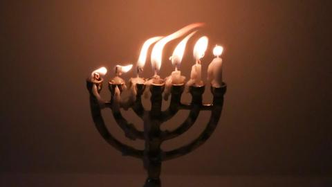 Flackernde Kerzenflammen in einer Menorah.