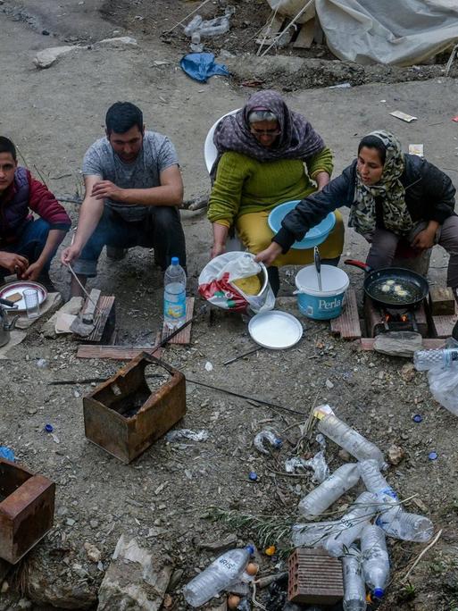 Eine Flüchtlingsfamilie bereitet in ärmlichsten Verhältnissen im griechischen Flüchtlingslager Moria auf Lesbos Essen zu.