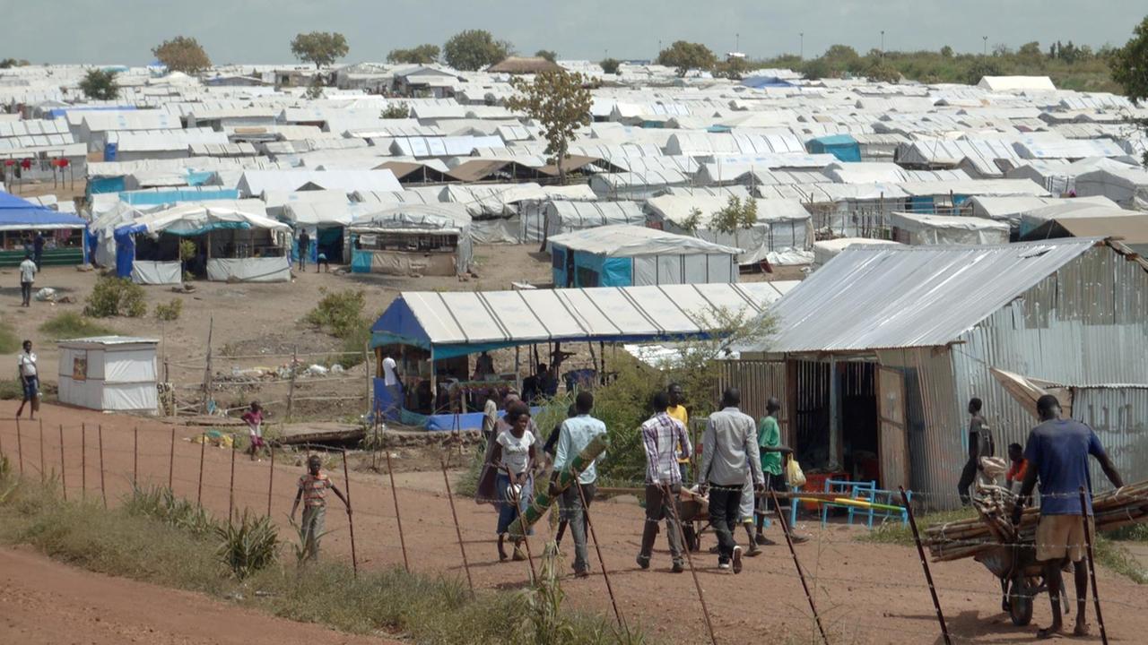 Flüchtlinge gehen am 15.06.2015 in Juba durch das UNO-Flüchtlingscamp