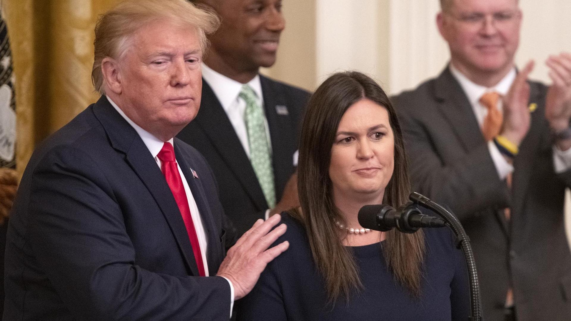 Trump mit Sanders, der er die Hand auf die Schulter legt am Tag ihres Rücktritts im Weißen Haus