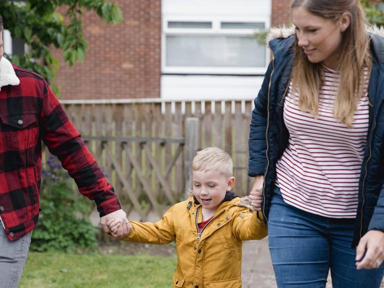 Vater und Mutter mit ihrem kleinen Sohn an der Hand